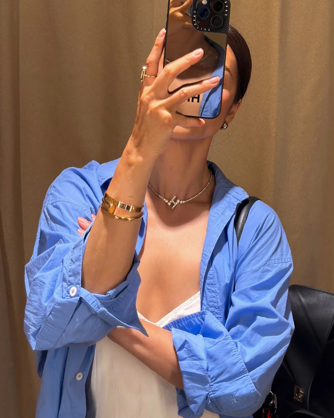 Hang Rutjes in the Signature Pavé Initial Necklace — an open collar, a plain tee, one letter at the throat.